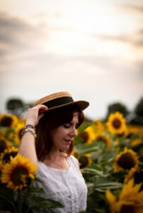 girl with straw hat in a sunflower field